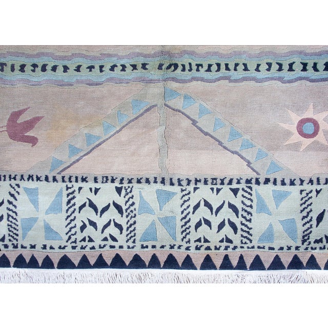 A charming and whimsical late 20th century Tibetan rug with with a highly stylized pattern with birds, suns, geometric and...