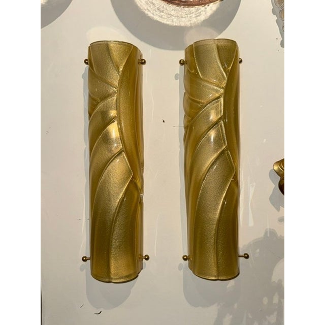 The product is a pair of modern Murano gold tube sconces.. These sconces are made with high-quality materials and...