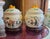 A pair of Chinese Chinoiserie handprinted rice pots from the early 1900's. They sit of heavily carved wood bases....