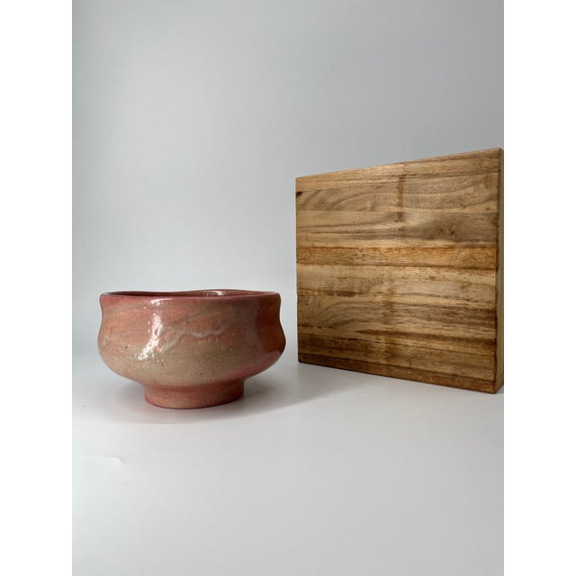 This is a vintage Japanese Aka-Raku (Red Raku) tea bowl, accompanied by its original wooden storage box (kiribako)....