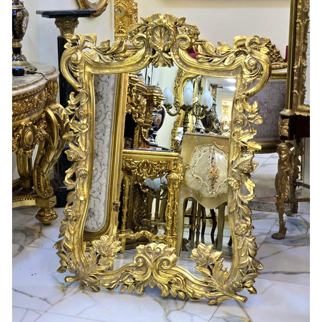 Beautiful vintage French-style wall mirror featuring an exceptionally ornate Rococo-Baroque inspired frame with intricate...