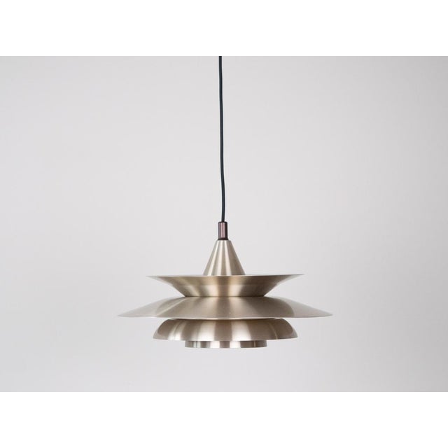 The lamp's form was designed based on the principle of a reflective system that directs light not only downward but also...