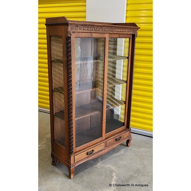This is a very fine antique quartered oak sliding glass door bookcase cabinet made by Paine's Furniture Company,...