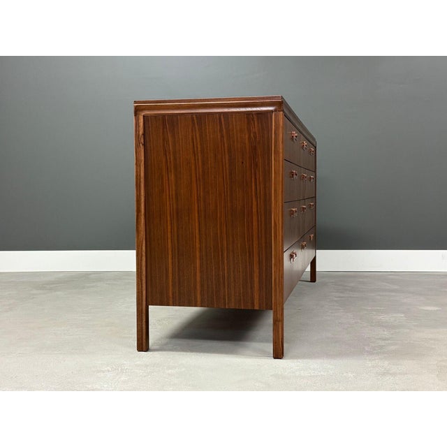 A mid century modern walnut twelve drawer cascading veneer dresser with polished copper drawer pulls by Mayflower...