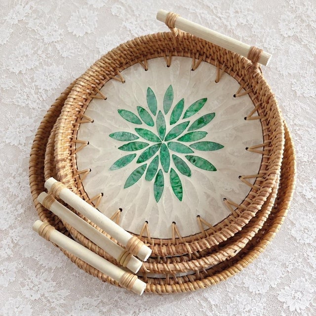 This set of three-piece round trays is handmade by Vietnamese craftsmen. It uses a natural rattan woven outer ring and is...
