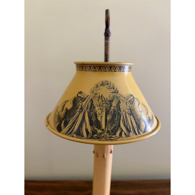 A classic bouillotte lamp rendered in warm brass, distinguished by its tailored yellow and bronze tole shade. The form...