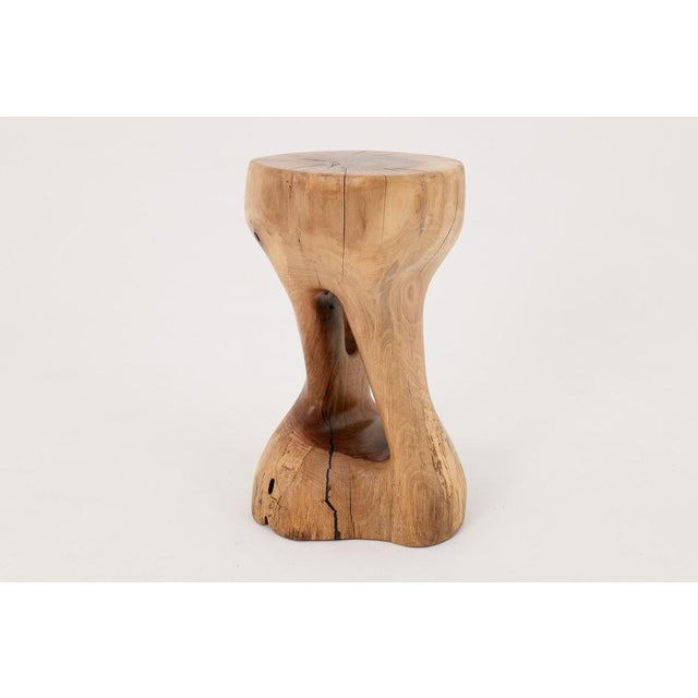 This sculptural side table is a one-of-a-kind piece, carved entirely by hand from a single solid hardwood log. Its form is...
