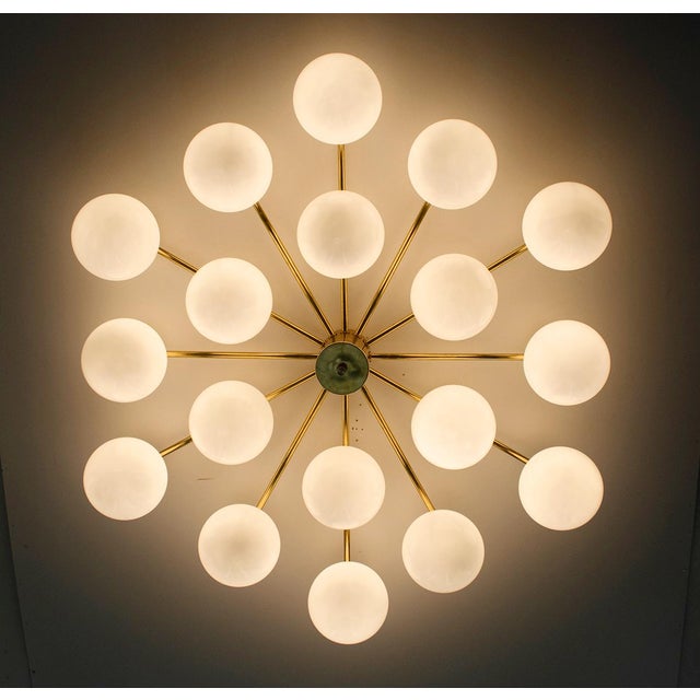Italian flush mount with 18 large glossy white Murano globes mounted on solid brass frame in unlacquered natural brass...