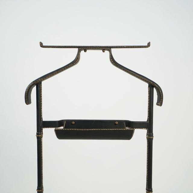 Nightstand with tubular metal structure imitating bamboo entirely covered with black leather saddle stiched. Elements in...