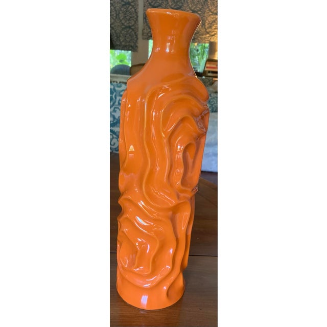 This is a charming mid-century style vase in a vibrant orange hue with an organically sculpted, freeform body and gently...
