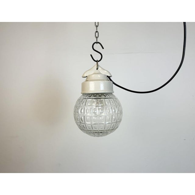 Vintage industrial light made in former Czechoslovakia during the 1970s. It features a white porcelain top and a glass...