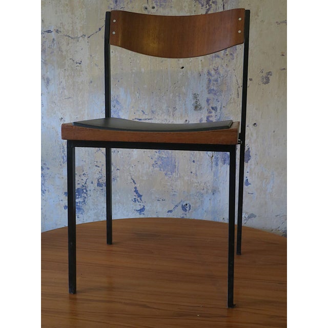 Unusual pair of stacking chairs in teak on iron frames with leatherette seats, 1960s.