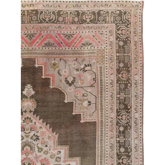This Mid-20th century Turkish Anatolian gallery carpet presents a richly layered composition centered by a large stepped...