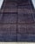 This hand-knotted Afghan Baluch rug lives entirely in the dark end of the spectrum — deep midnight indigo, plum, dusty...