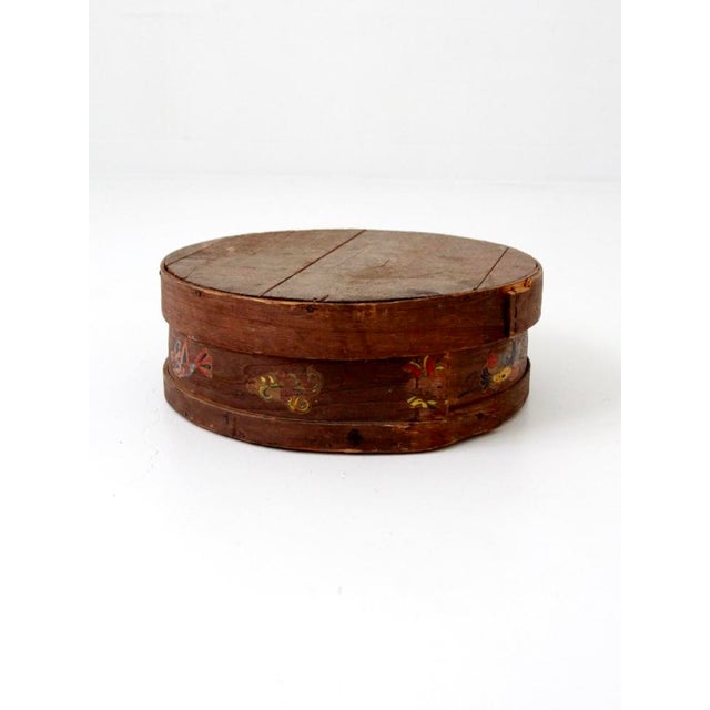 This antique folk art cheese box features a bentwood band design with hand-painted birds and flowers along the sides. The...