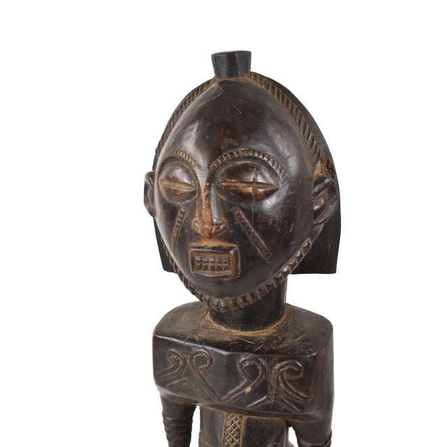 This distinctive figure, characterized by square shoulders and scarified belly, embodies the unique essence of a Buyu...