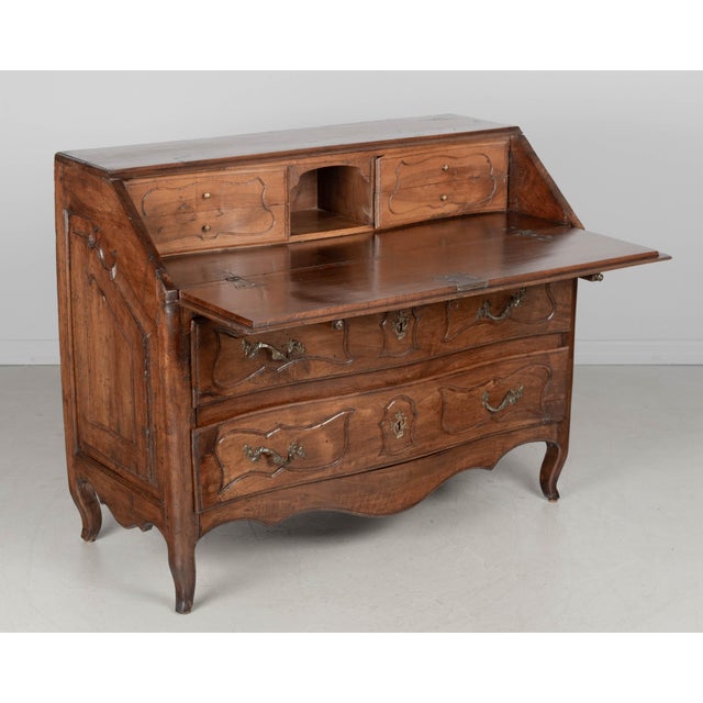 An 18th Century Louis XV style Italian scriban or slant front desk. Made of solid walnut with serpentine front, raised...