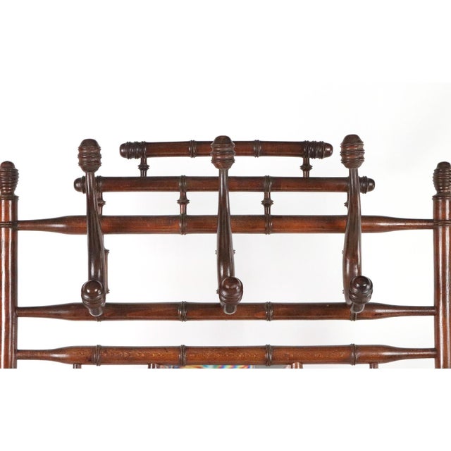 Belgian late Victorian hall tree with a beveled mirror in the Aesthetic design. The hardwood construction has been turned...