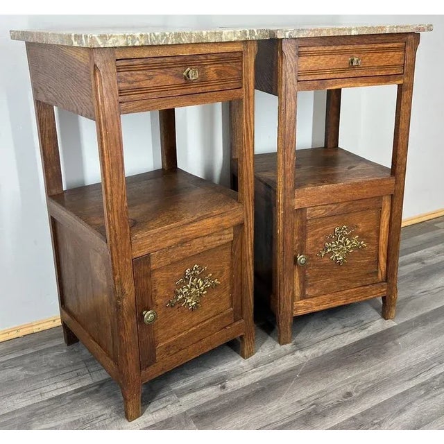 A refined pair of Antique French oak bedside tables , each topped with beautifully veined brown marble that adds a touch...
