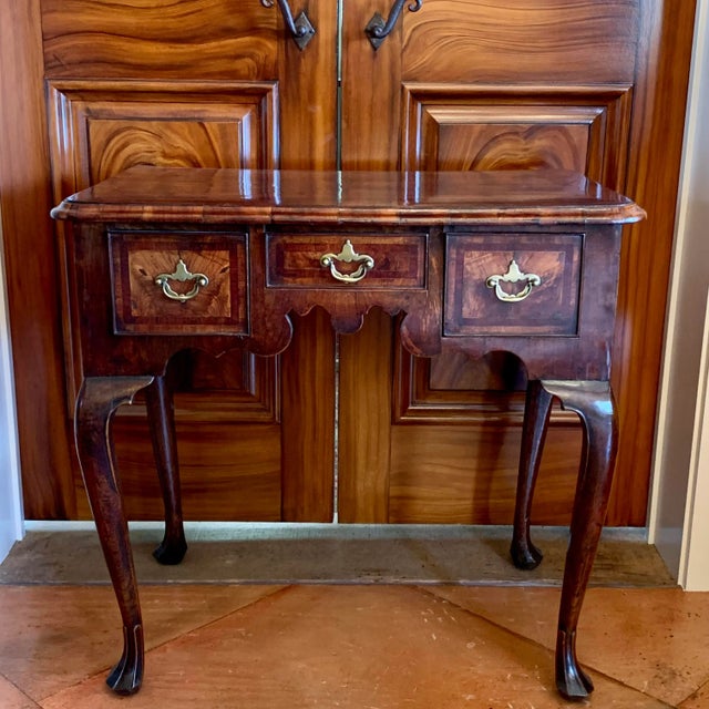 A very elegant English Georgian period lowboy with a complex and gracefully shaped apron in the front and ogival arched...