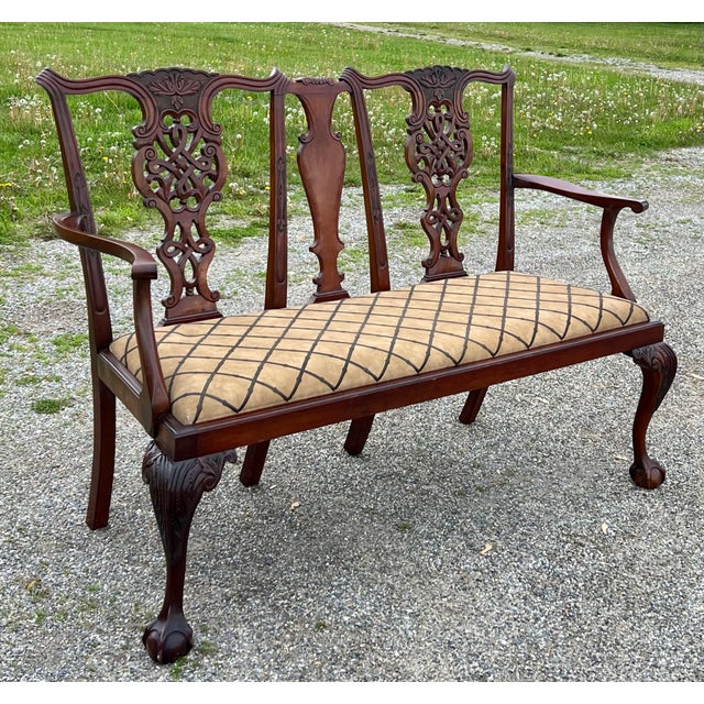 Exceptionally carved vintage 1940’s mahogany Chippendale settee. The backrest features two highly ornate, intricately...