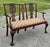Exceptionally carved vintage 1940’s mahogany Chippendale settee. The backrest features two highly ornate, intricately...
