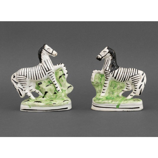 Pair of Staffordshire Painted Ceramic Zebras, 19th century, on oval bases. 6.25" H x 5.5" W x 3" D. Provenance: An Upper...