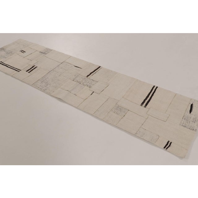 Handwoven in hemp, this 2x9 vintage Turkish kilim patchwork runner, dating to circa 1950–1960, exemplifies a thoughtful...