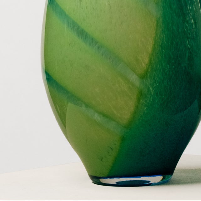 Crafted from white Murano glass with a blue striped design over a gradient from white to a soft green, this vase features...