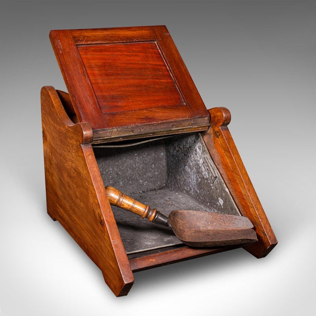 This is an antique coal purdonium. An English, walnut and brass fireside fuel keep, dating to the Victorian period, circa...