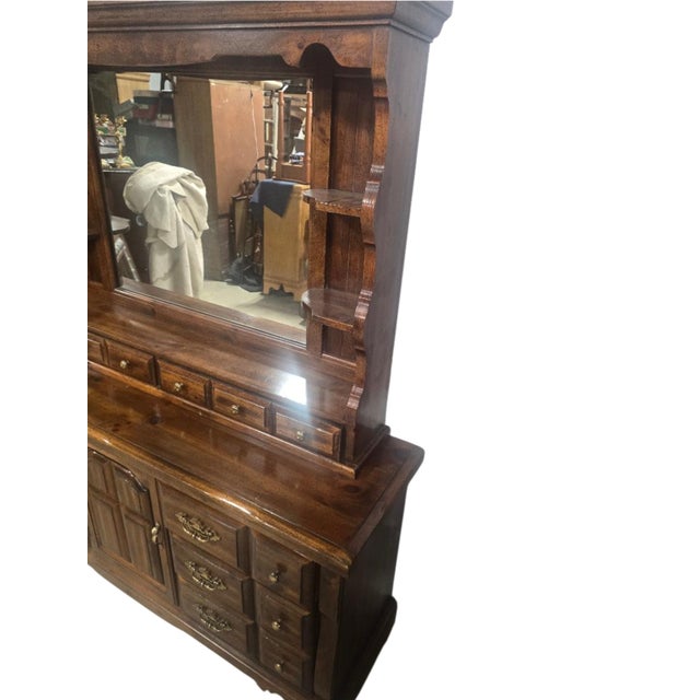 A substantial late-20th-century rustic dresser distinguished by its warm brown finish, architectural paneled details,...