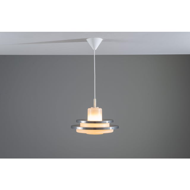 This rare vintage pendant by Doria is a striking example of refined German lighting design, distinguished by its elegant...