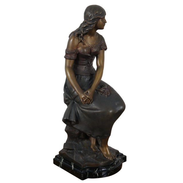 Antique bronze sculpture with beautiful patina, mounted on a black marble base, portraying the seated figure of a young...