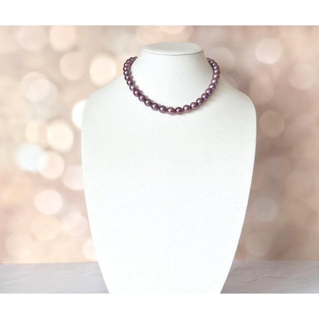 A refined necklace composed of Edison pearls displaying a rare natural dark purple color with pronounced metallic...