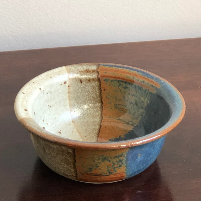 Offering a small, but dramatic mid-century modern style studio pottery bowl with vibrant, angled glazing in tones of...