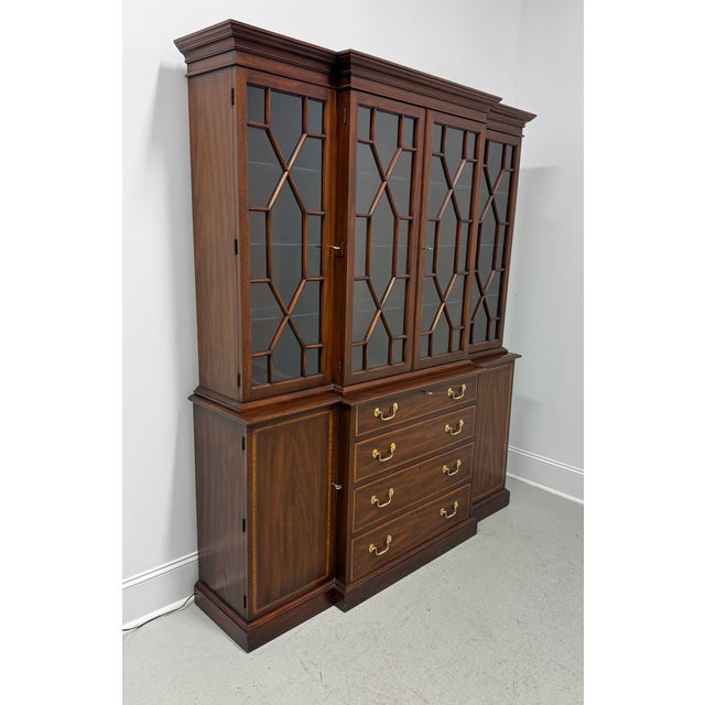 A Traditional style breakfront china display cabinet by Henkel Harris, of Winchester, Virginia, USA. Mahogany with brass...