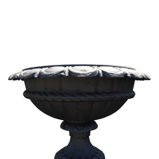 This offering presents a distinguished pair of antique cast iron garden urns, dating to circa 1900. Crafted from robust...