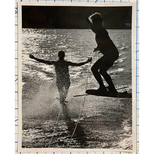 1980s black and white photograph of two water-skiers on a lake. Publication information typed on the back.
