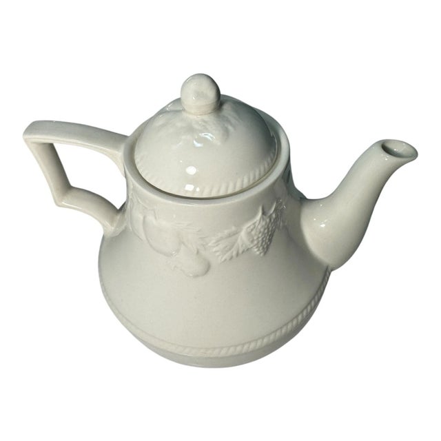 Vintage mid-century English pottery teapot with a classic white glaze and embossed grape and vine design. Marked “Made in...