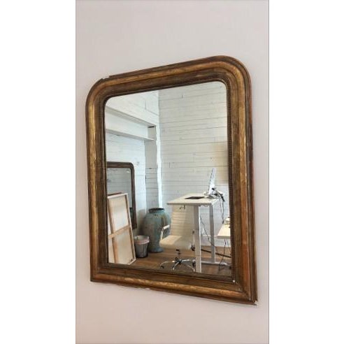 A 19th Century French Louis Philippe mirror with a gilded wooden frame, featuring the period’s characteristic rounded...