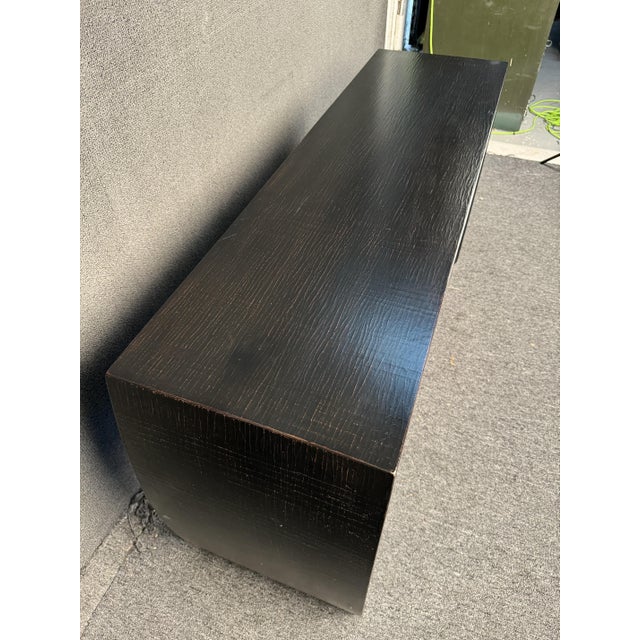 Unique curved console in black. Featuring a distressed finish, and eye catching sculpted shape. Perfect for any living...