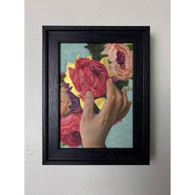 This artwork depicts a delicate hand gracefully holding a bouquet of vibrant peonies, their lush petals rendered in rich...