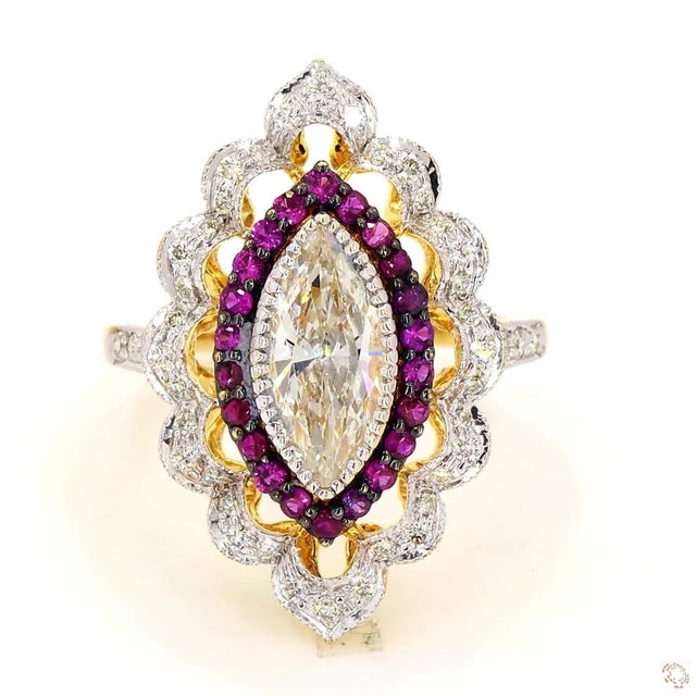 This cocktail ring centers on a 1.02-carat diamond in an elongated marquise cut. It is set with diamond and ruby accents...