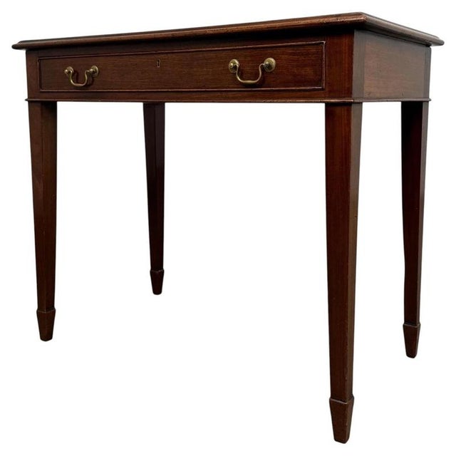An elegant 19th-century English writing table, finely crafted from mahogany in the Georgian style and distinguished by its...
