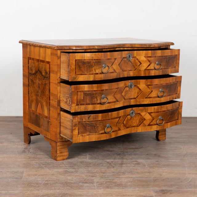 This 18th century rococo chest of drawers is accented with contrasting inlaid mahogany and walnut trim along the top,...
