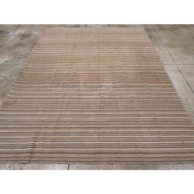 This Mid-20th century Turkish Flatweave Kilim rug, embodies the minimalist beauty and timeless appeal of traditional...