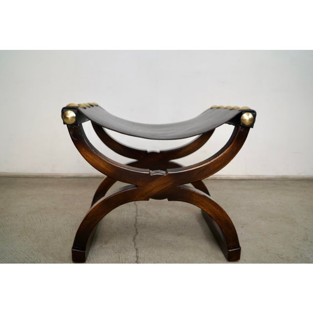Vintage Hollywood Regency leather saddle stool for sale. It's a very unique saddle bench with a sling leather seat, and...