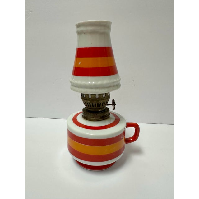 Small ceramic oil lantern. White with orange and red striped pattern.
