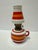 Small ceramic oil lantern. White with orange and red striped pattern.