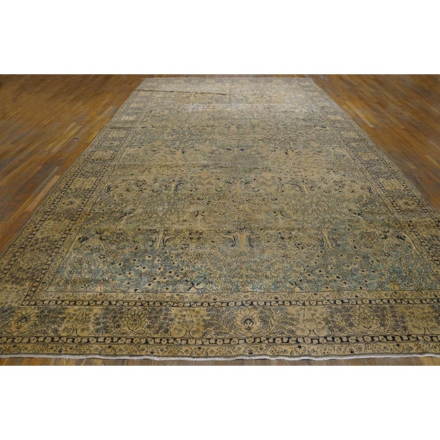 The moderately finely woven northern Indian “Laristan” carpet features a field abrashing from cream to pale grey with a...